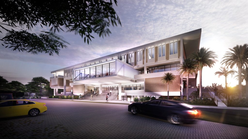 A modern, multi-story building with large glass windows, palm trees, steps leading to the entrance, people walking, and cars parked in front during sunset.