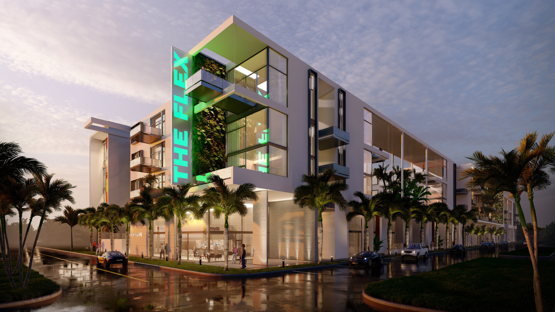 Modern multi-story building with THE FLEX in green neon lights, large glass windows, palm trees along the street, and people walking on a wet sidewalk at sunset.