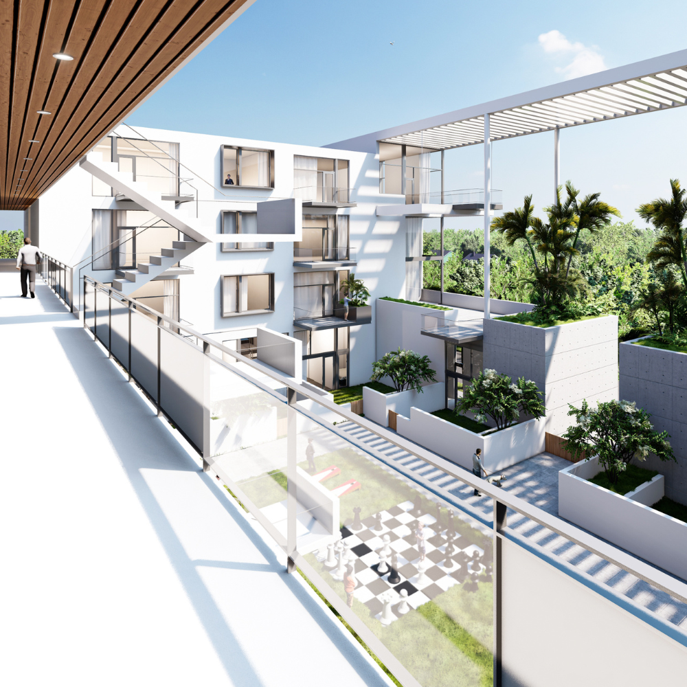 Modern apartment complex with white walls, glass railings, outdoor plants, staircases, and a large chessboard in the courtyard, viewed from an upper walkway on a sunny day.