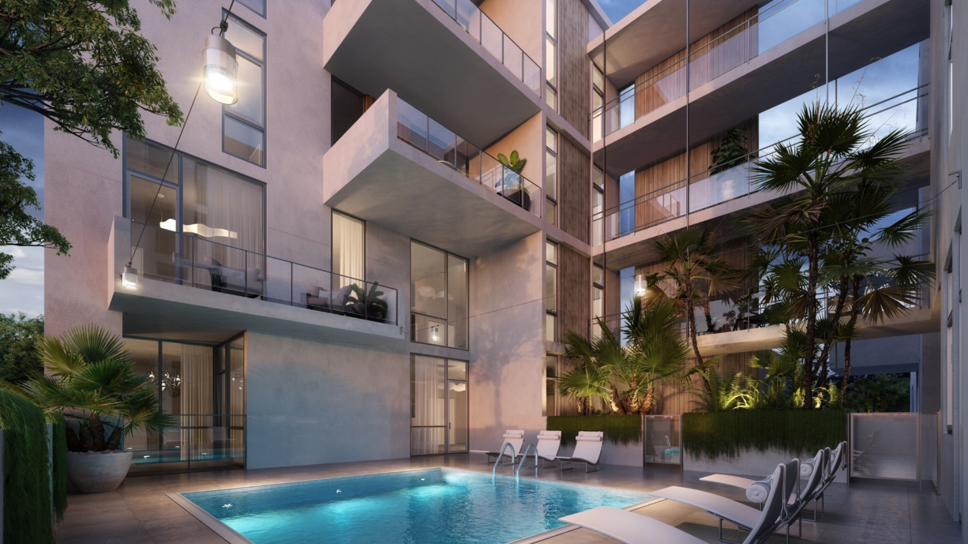 Modern apartment building with balconies, large windows, and a well-lit outdoor swimming pool surrounded by lounge chairs and tropical plants in the courtyard at dusk.