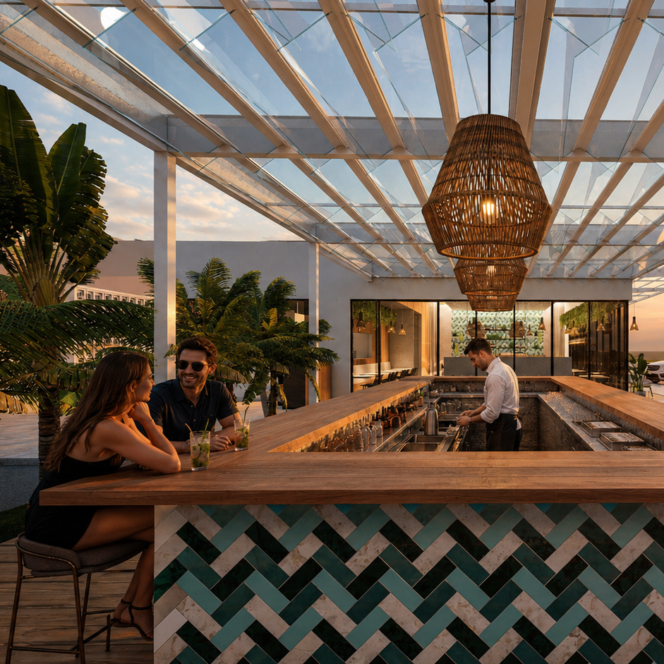 A couple sits at a stylish outdoor bar with a geometric tile design, under a glass roof with hanging lights. A bartender prepares drinks, surrounded by tropical plants at sunset.