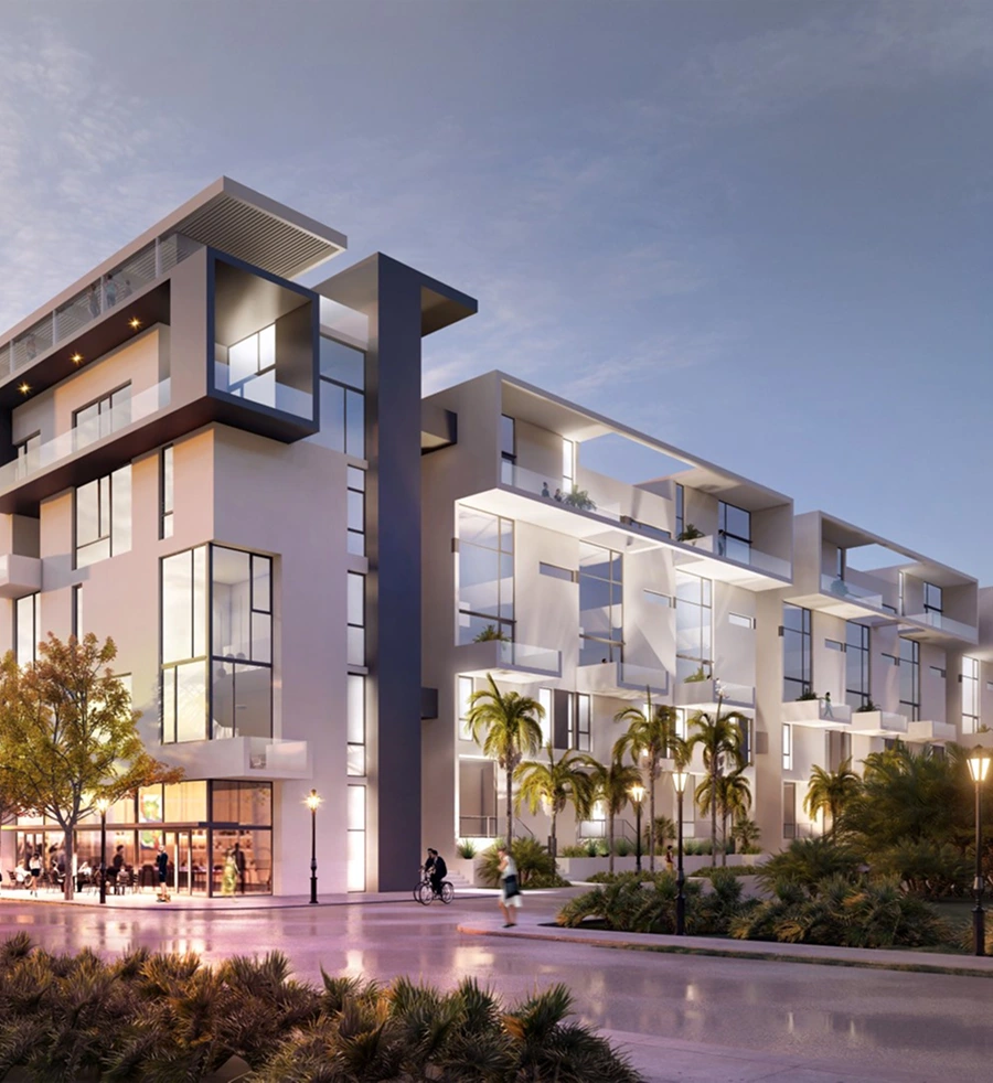 Modern multi-story apartment building by Halflants + Pichette with large glass windows, balconies, and palm trees. People relax outside a ground-floor café at dusk beneath a partly cloudy sky.